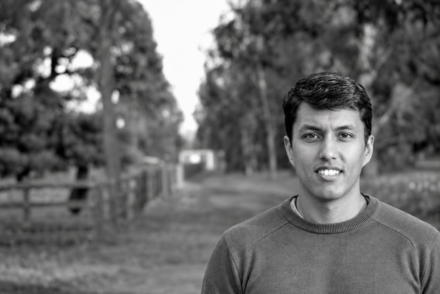 Joyanto Roy standing beside a tree-lined path.